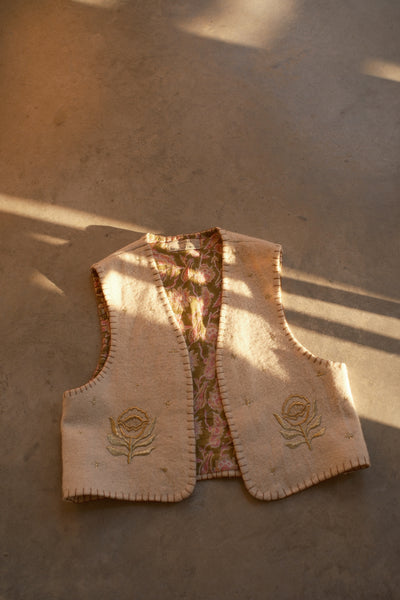 Wool vest with floral patterns and embroidered designs. Artisan fashion, sustainable luxury.